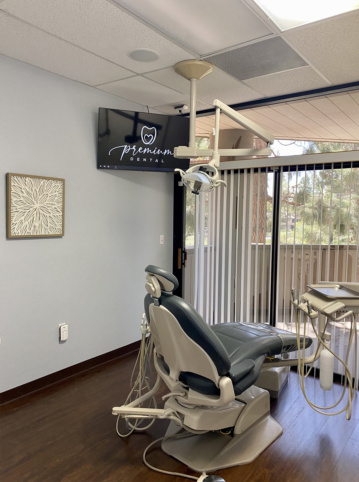 The image shows an interior view of a dental office with a dental chair and equipment, featuring a sign that reads  Premium Dental .