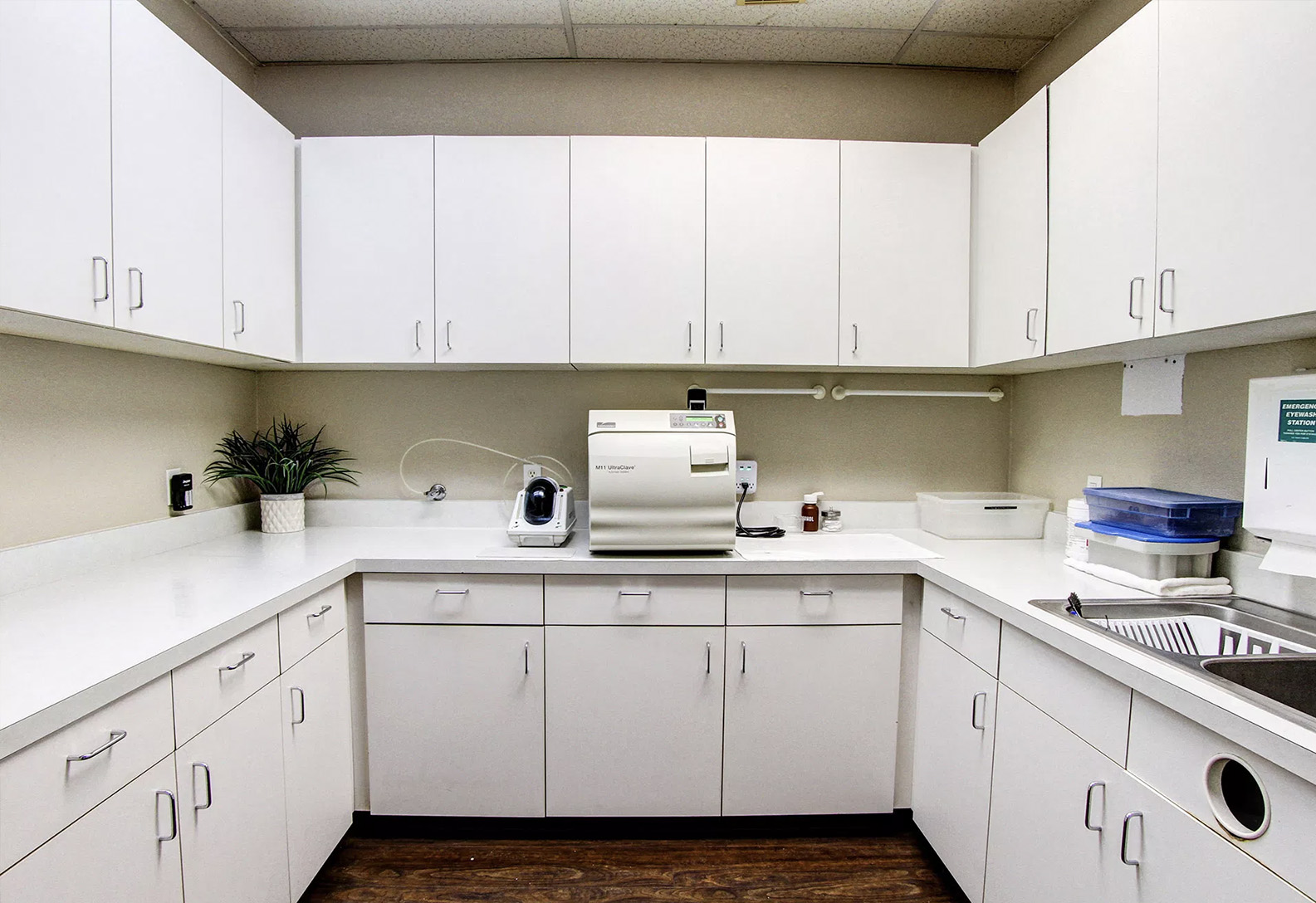 This is an interior photograph of a clean, well-organized office space with white cabinets and countertops.
