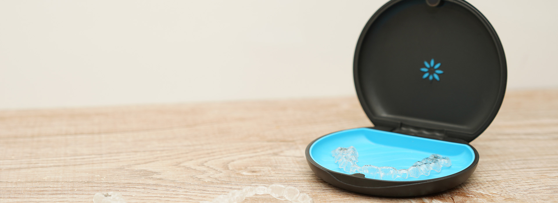 The image shows a smart home device, specifically an air purifier with a blue light on the front, sitting on a wooden surface.